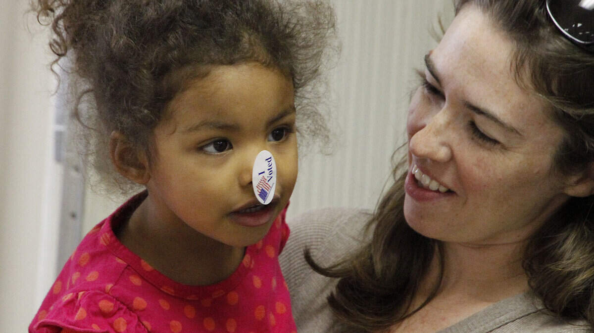 Selah Rust, 2, wore an "I Voted" sticker on her nose as she waited in line with her mother Anne Rust at the Woodland precinct in Woodland Christian Church during voting on Tuesday, Nov. 2, 2010 in Lexington, Ky.     Photo by David Perry | Staff