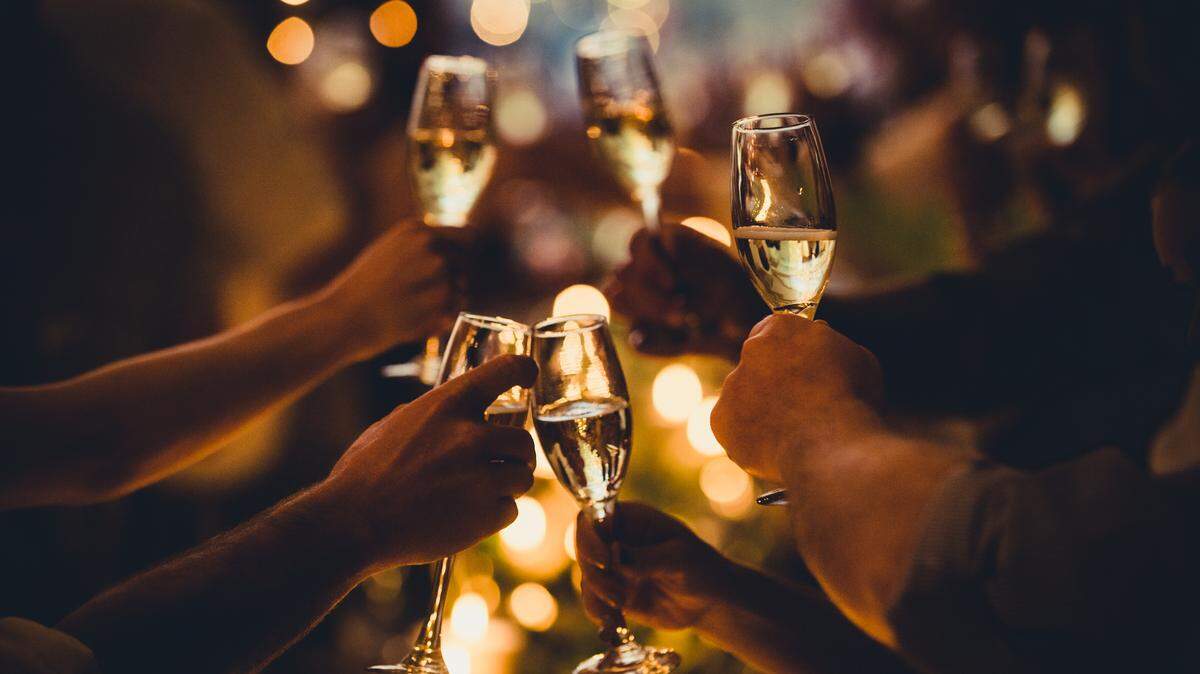 In this stock image, champagne flutes clink in a celebratory toast at a New Year's Eve party.