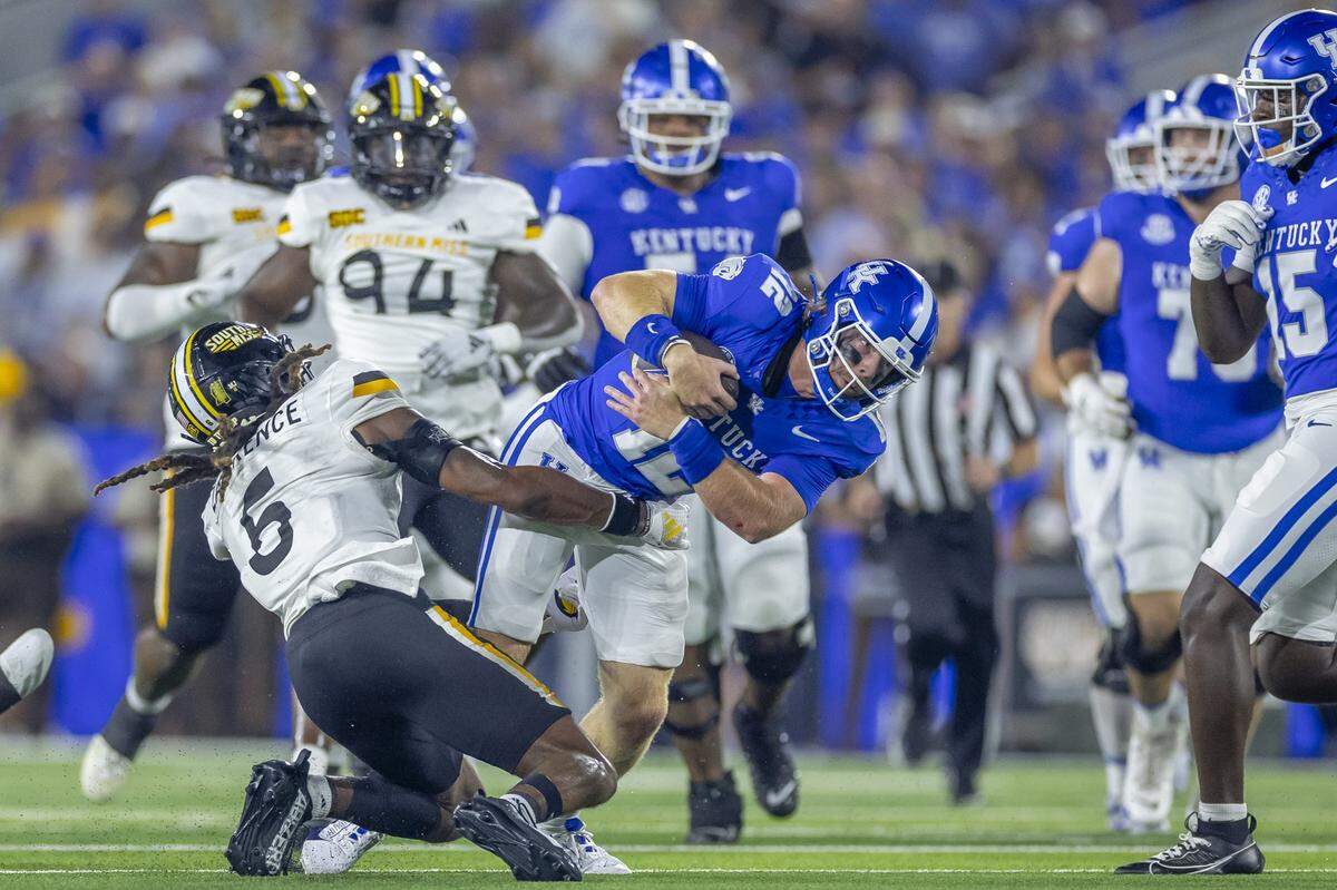 Kentucky quarterback Brock Vandagriff (12) is wrapped up by Southern Miss safety Dylan Lawrence (6) during Saturday’s game at Kroger Field.