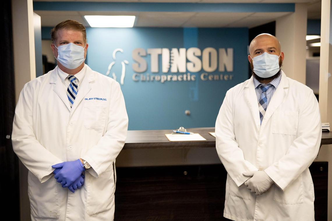 Chiropractic Dr. Jeff Stinson, left, stands with Life University intern Jeremy Farmer, right, at the front desk of Stinson Chiropractic Center the day the facility could reopen, April 27, 2020, after a ruling by Gov. Andy Beshear allowing select non-urgent medical facilities to reopen amid the COVID-19 pandemic.