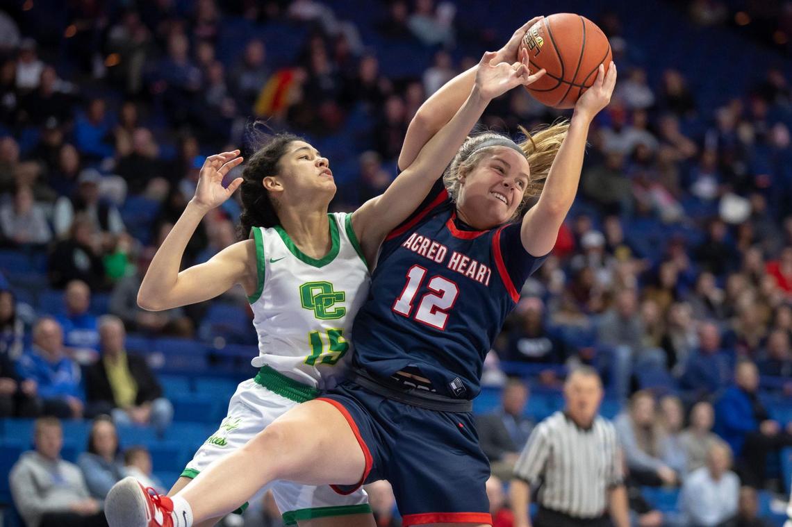 Owensboro Catholic’s Aubrey Randolph (15) and Sacred Heart’s Claire Russell (12) fight for a rebound during the quarterfinals of the Sweet 16 on Friday in Rupp Arena.