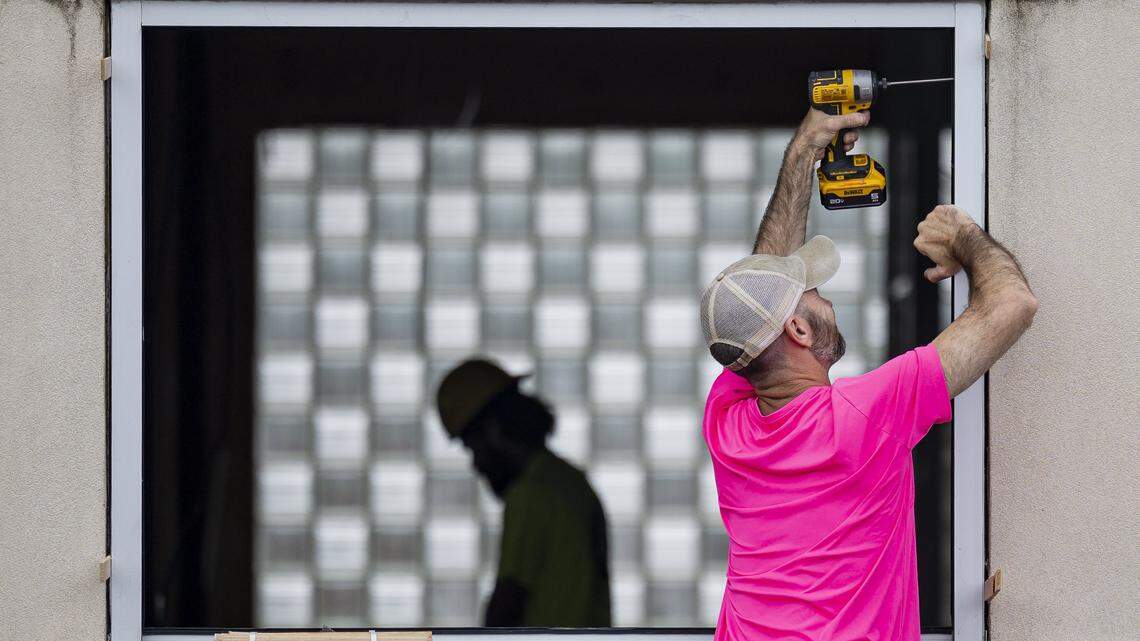 A worker from Aladdin’s Glass drills new frames into the walls during construction of a new dispensary on Wednesday, July 9, 2025, at the old Frisch's Big Boy in Hamburg in Lexington, Ky.