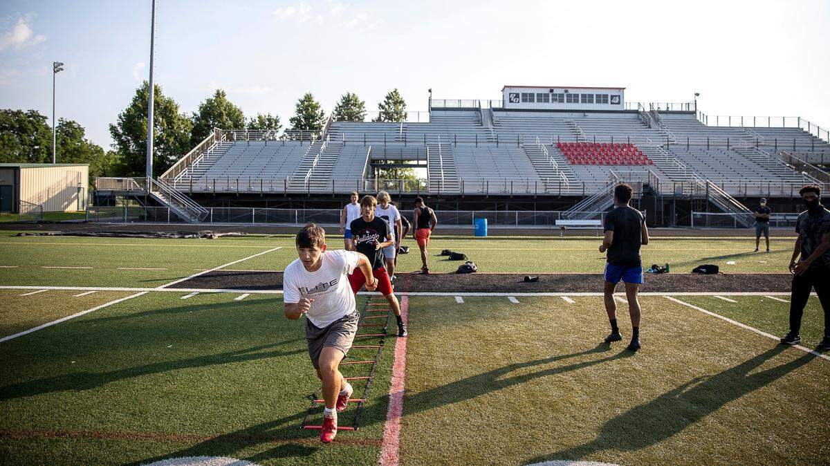 Members of the Paul Laurence Dunbar High School football team participate in a voluntary workout on the football field at Jon R. Akers Stadium at the school on July 2., 2020.