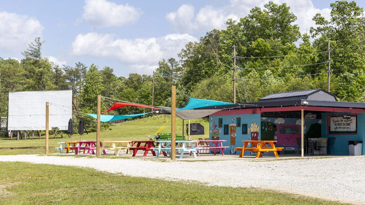 Outdoor seating overlooks the lone remaining screen at The Drive-In Diner, a restaurant located in the renovated concession stand of the Mountain View Drive-In in Stanton, Ky. The diner leans heavily into its movie-lot heritage, hosting community cruise-in car shows and seasonal free movies where patrons can bring lawn chairs and blankets. There is also a sand volleyball court on the property.