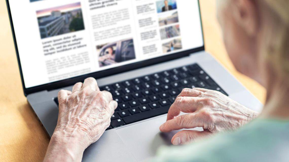 An old woman browses the internet in this stock image.