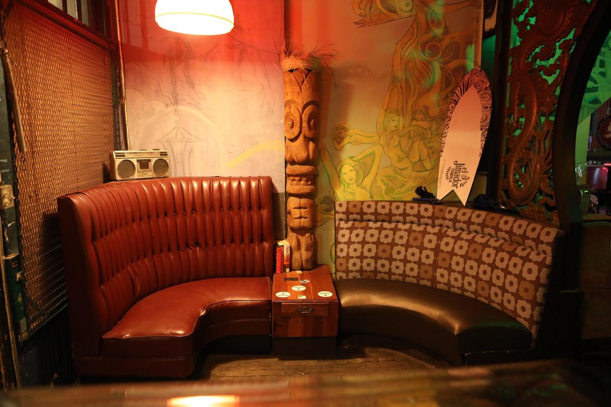 A Tiki totem pole stands between banquette booths on the side of the action at Green Lantern Bar at 497 West Third St. in Lexington.