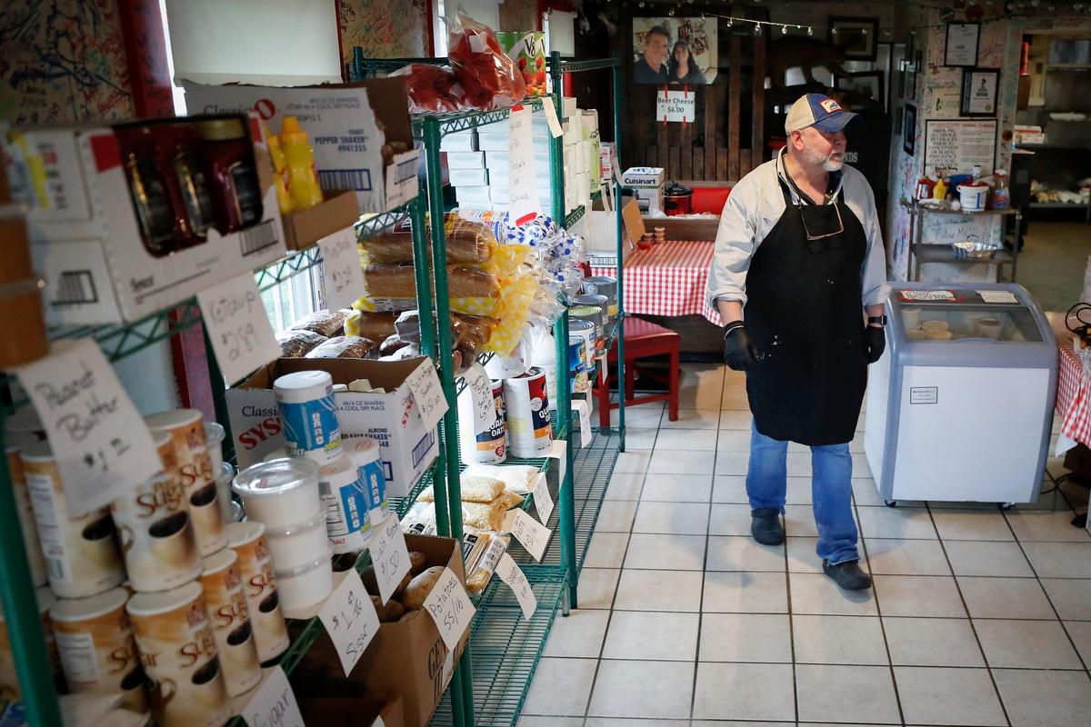 Red State BBQ owner David Carroll, of Lexington, Ky., walks past various items for sale in a pop-up grocery store at Red State in Lexington, Friday, April 17, 2020. Carroll decided to set up the small store inside Red State about 4 weeks ago.