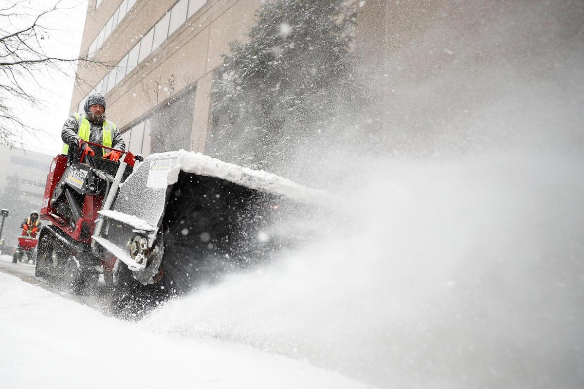 Jake Buchanan, of Lawrenceburg, Ky., works to clear snow along West Main Street in Lexington, Ky., Thursday, Jan. 6, 2022.