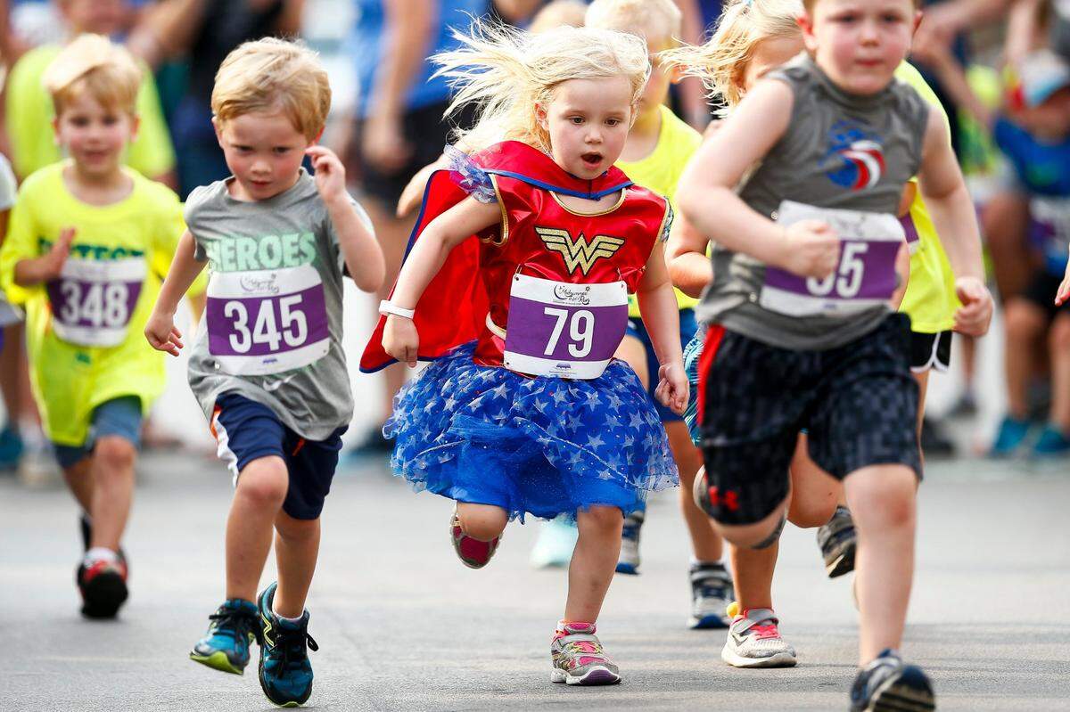 Caroline Pickett, 4, of Lexington, center, competed in a Wonder Woman costume during the four-year-old heat of the 2018 Fastest Kid in Town competition in downtown Lexington. The year’s event will be Saturday.