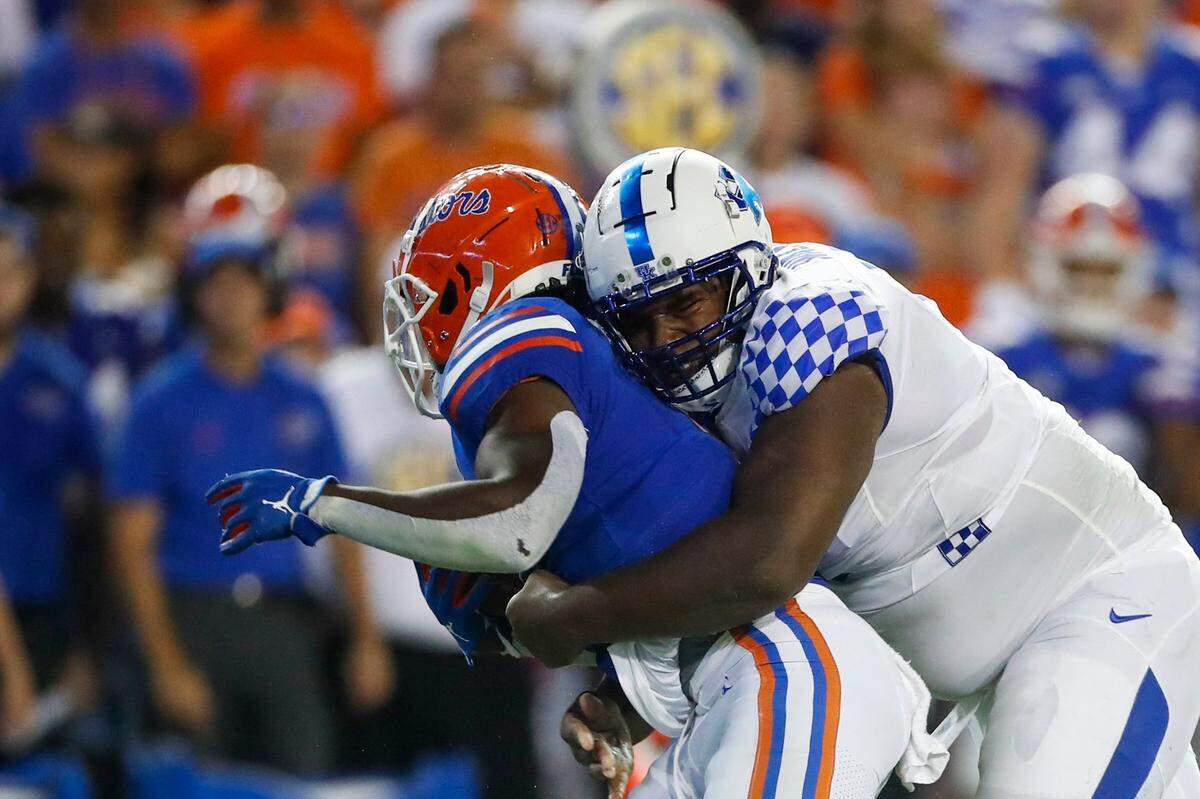 Kentucky defensive tackle Deone Walker, right, tackles Florida running back Nay’Quan Wright for a loss of yards Saturday.