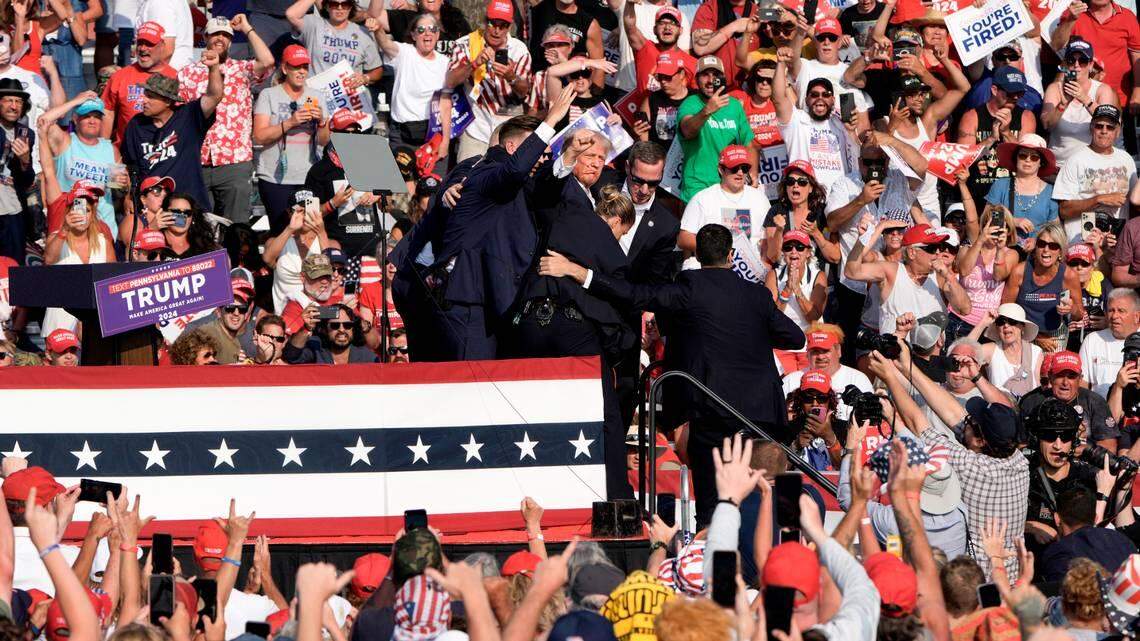 Former President Donald Trump is surrounded by Secret Service agents at a campaign rally in Butler, Pa, on Saturday, July, 13, 2024. Trump was escorted off the stage by Secret Service agents and into his motorcade just minutes into his rally in Butler, Pa., on Saturday, after a series of pops that sounded like gunshots rang out.