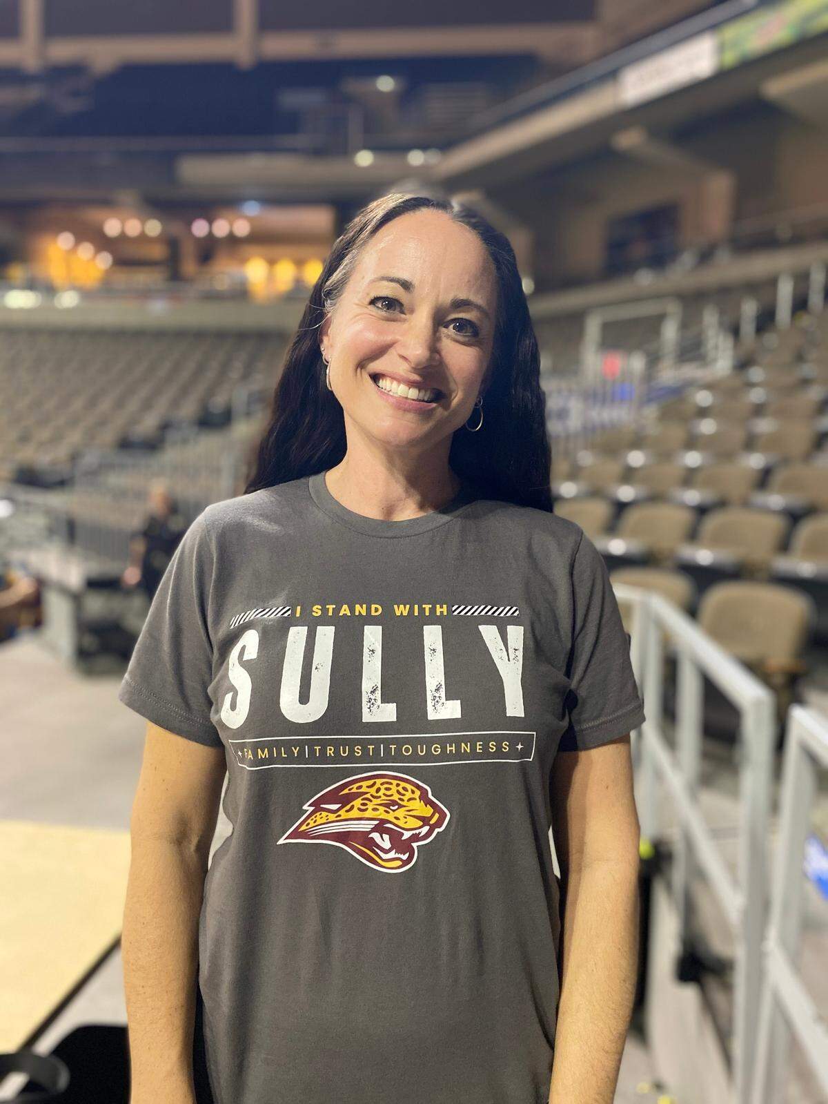 Andrea Sullivan, wife of Tim Sullivan, wore a T-shirt designed by one of her husband’s supporters. “He’s gone above and beyond what the principal’s asked,” Andrea Sullivan said of Tim’s attempts to keep his coaching job.