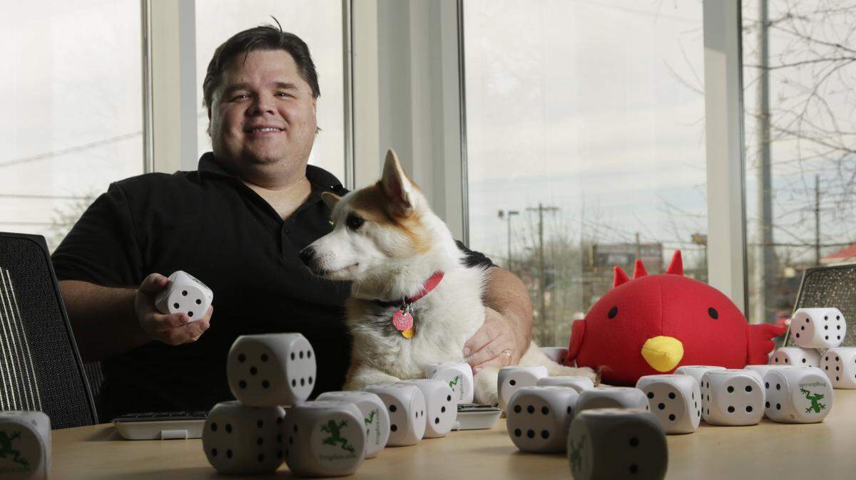 Michael Hartman, founder of Frogdice, sat with the office mascot at the video game company's offices on Winchester Road. Hartman launched the company in 1996, when "people felt that if you were going to do something on the Internet, it should be free."       