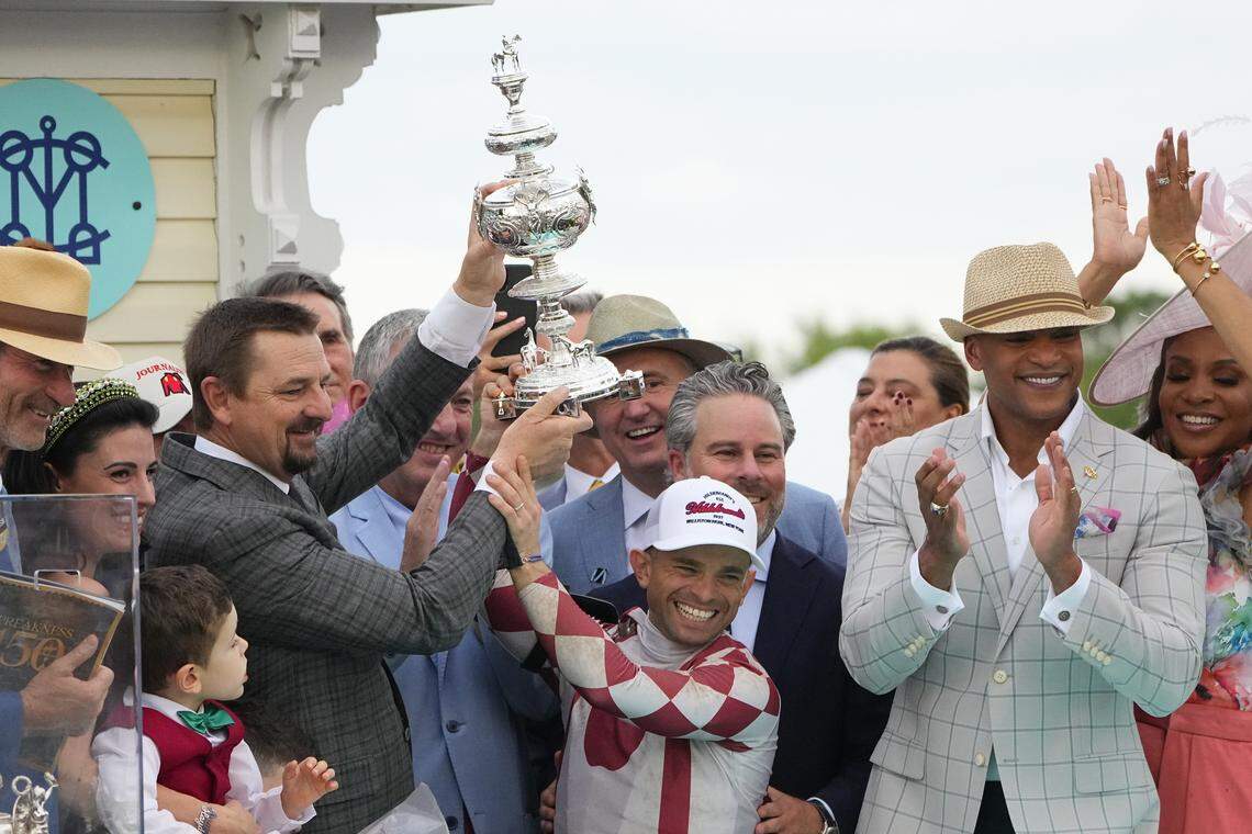 May 17, 2025; Baltimore, Maryland, USA; Trainer M W McCarthy and jockey Umberto Rispoli hold up the Preakness Stakes Trophy at Pimlico Race Course in Baltimore, MD.  Mandatory Credit: Gregory Fisher-Imagn Images
