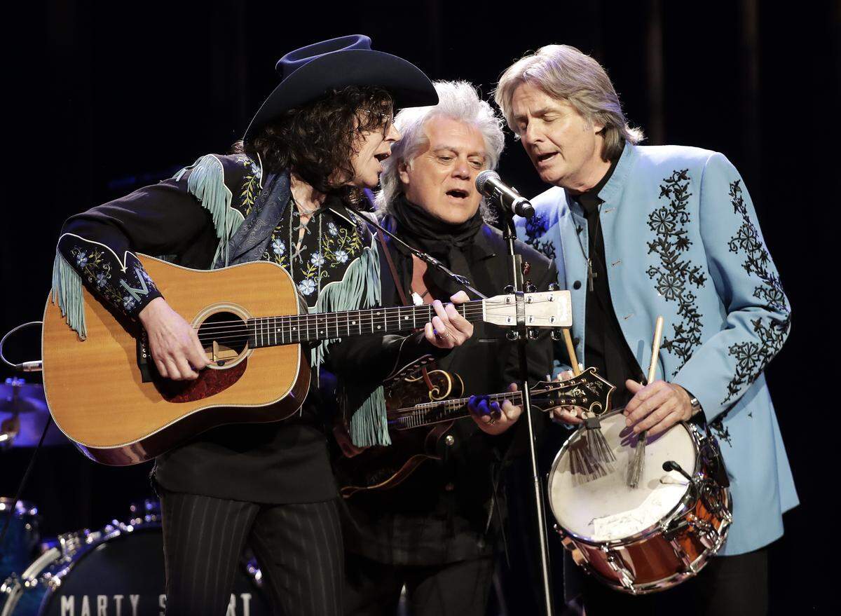 Marty Stuart, center, performs with members of his band, the Fabulous Superlatives -- guitarist Kenny Vaughan (left) and drummer Harry Stinson (right) during Marty Stuart’s Late Night Jam at the Ryman Auditorium Thursday, June 7, 2018, in Nashville, Tenn.