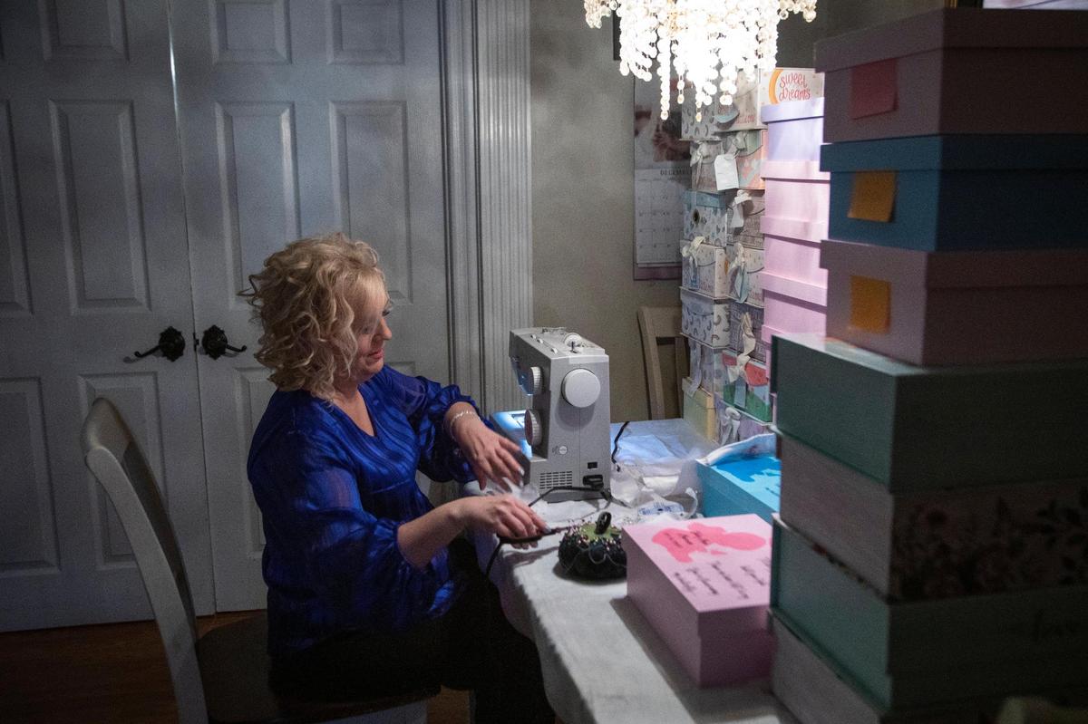Tammy Marcum finishes sewing the last of some outfits before delivering boxes to Baptist Health in Lexington, Ky., Monday, December 14, 2020. Marcum has delved hundreds of these boxes to hospitals throughout central and eastern Kentucky for grieving parents who have lost children. “Knowing the heartbreak of that, I would have loved to have one of the boxes that I make, because that would have meant everything to me,” Marcum said.
