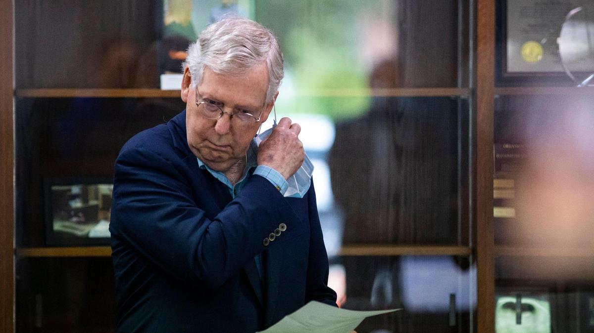 Sen. Mitch McConnell takes off a face mask before speaking during a press conferences at Sterling Health Care in Mt. Sterling, Ky., Wednesday, July 8, 2020.