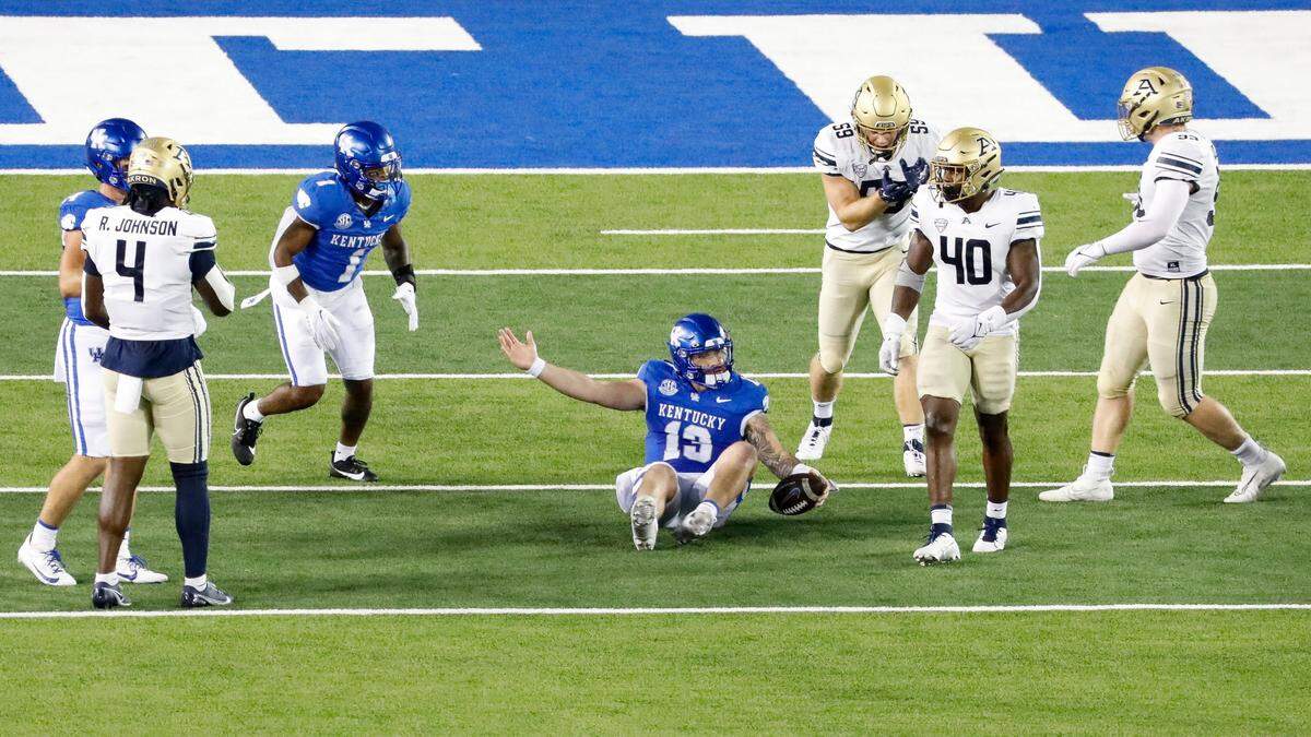 Kentucky Wildcats quarterback Devin Leary (13) lies on the ground dejected after recovering a loose ball after a bad snap during the first half of a football game against Akron at Kroger Field in Lexington, Ky., Saturday, Sept. 16, 2023.