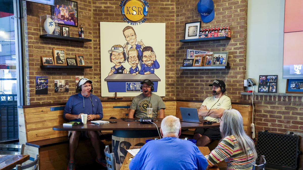 From left, Matt Jones, Ryan Lemond and Drew Franklin broadcast a live KSR radio show, Thursday, Aug. 28, 2025, at KSBar & Grille in Lexington, Ky. The popular sports bar recently underwent a menu and restaurant renovation that included new UK memorabilia, especially in the around where they do the radio show.
