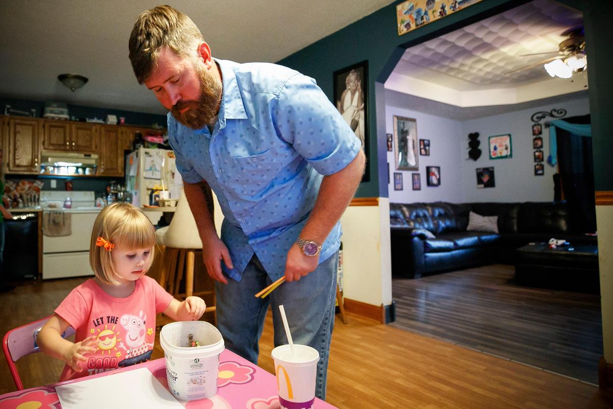 Brandon Humphries plays with his three-year-old daughter in their home in Rineyville on a recent Wednesday. Humphries was mistakenly issued a summons to appear in front of a Fayette County judge for alleged abuse and neglect of his daughter.