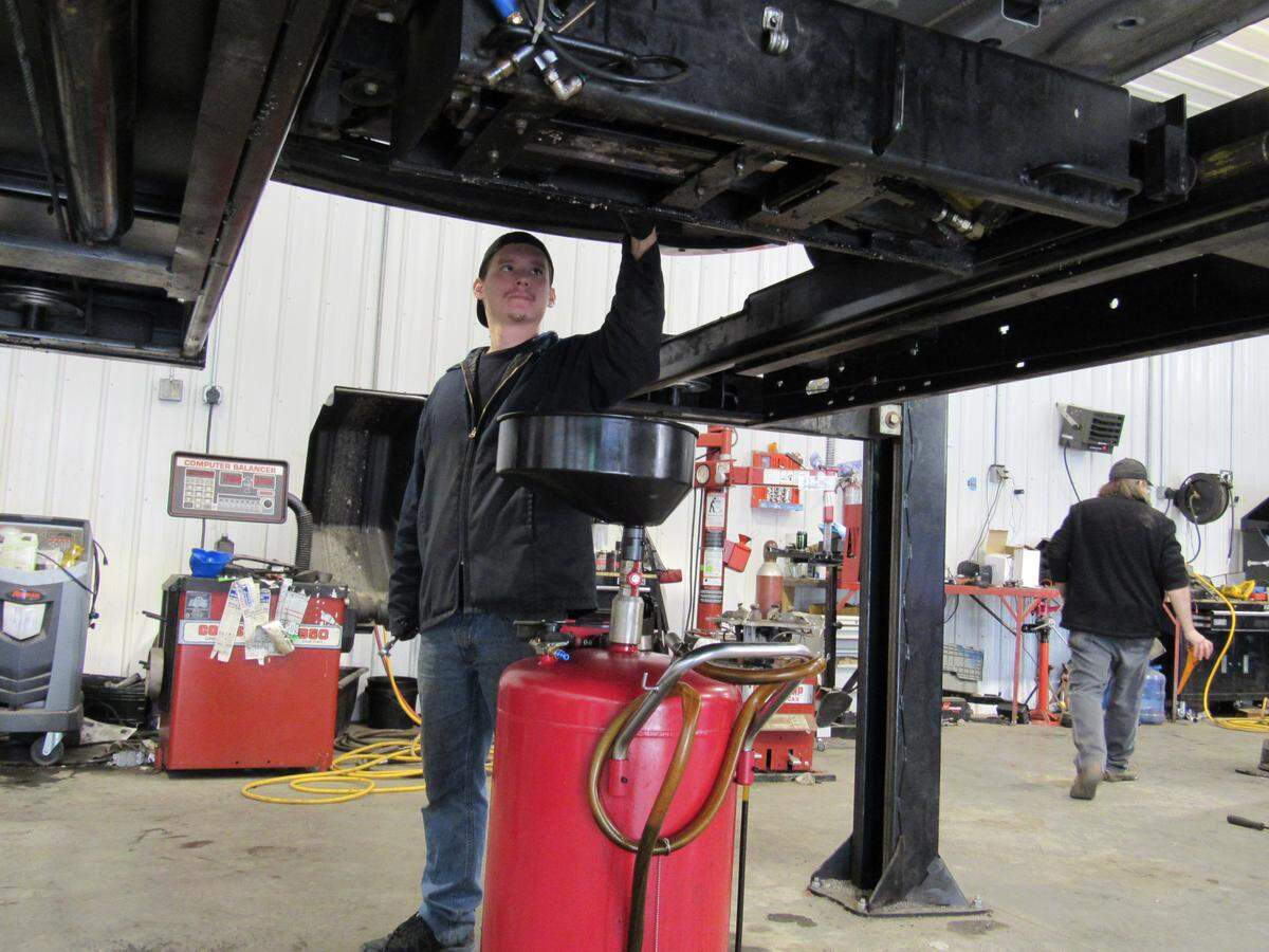 Rafael Gonzalez changes the oil on a vehicle at Second Chance Auto in Louisa, Ky., in November 2019. The shop provides training for recovering addicts.