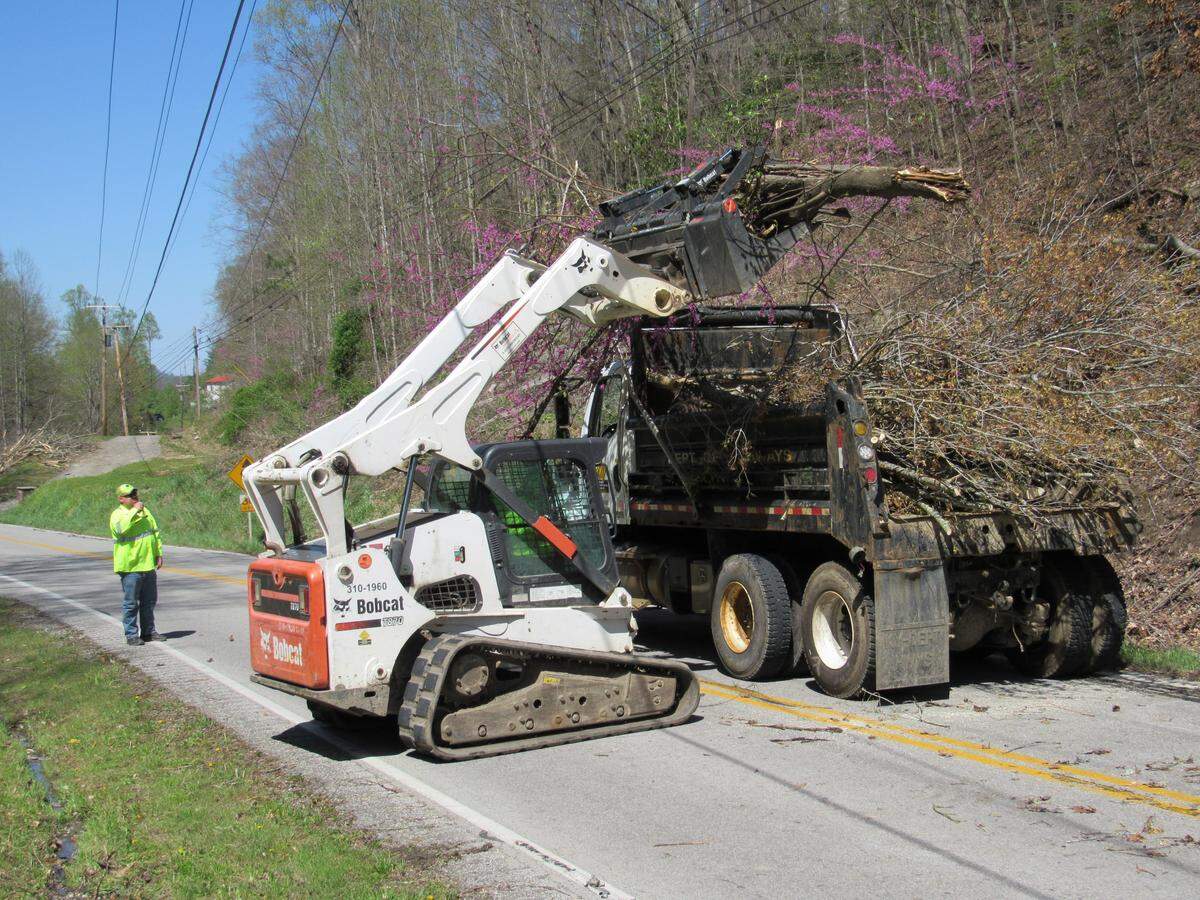 State Transportation Cabinet workers cleared downed tree limbs from along power lines and roads in Leslie County on April 15, 2020.