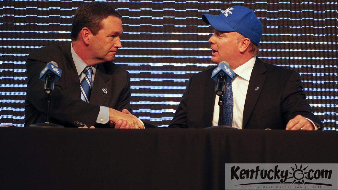 UK Athletics Director Mitch Barnhart, left, shook hands with new football coach Mark Stoops on Sunday as Stoops was introduced as UK's new football coach.  Photo by Mark Cornelison | Staff