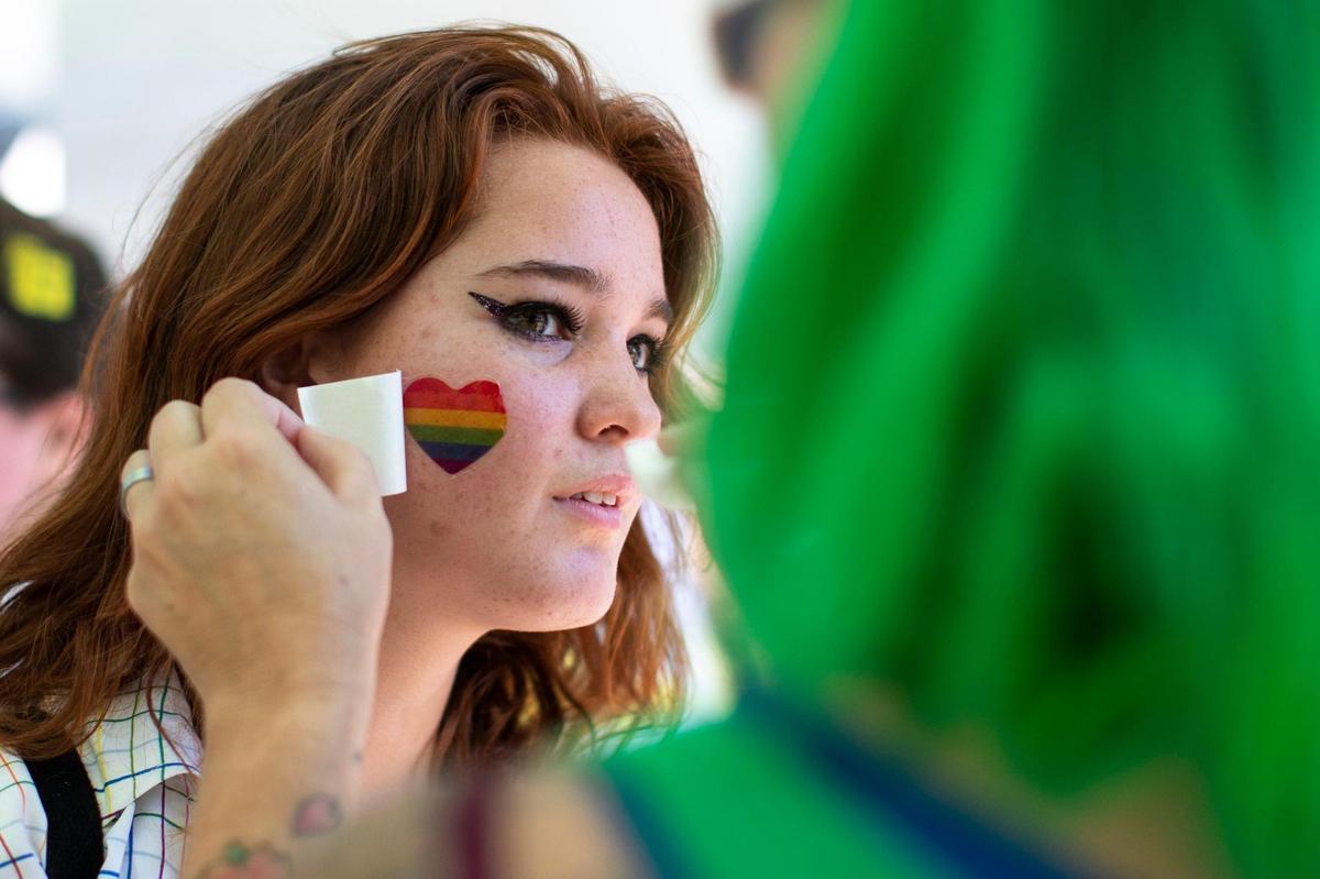 Attendees receive temporary, decorative tattoos during the annual Lexington Pride Festival in front of the Robert Stephens Courthouse in Lexington, Ky., Saturday, June 25, 2022.