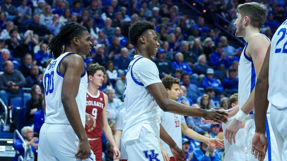 Kentucky’s Jaxson Robinson, center, and forward Andrew Carr, right, celebrate as Otega Oweh (00) watches after a made basket by Robinson during Wednesday’s game against Colgate.