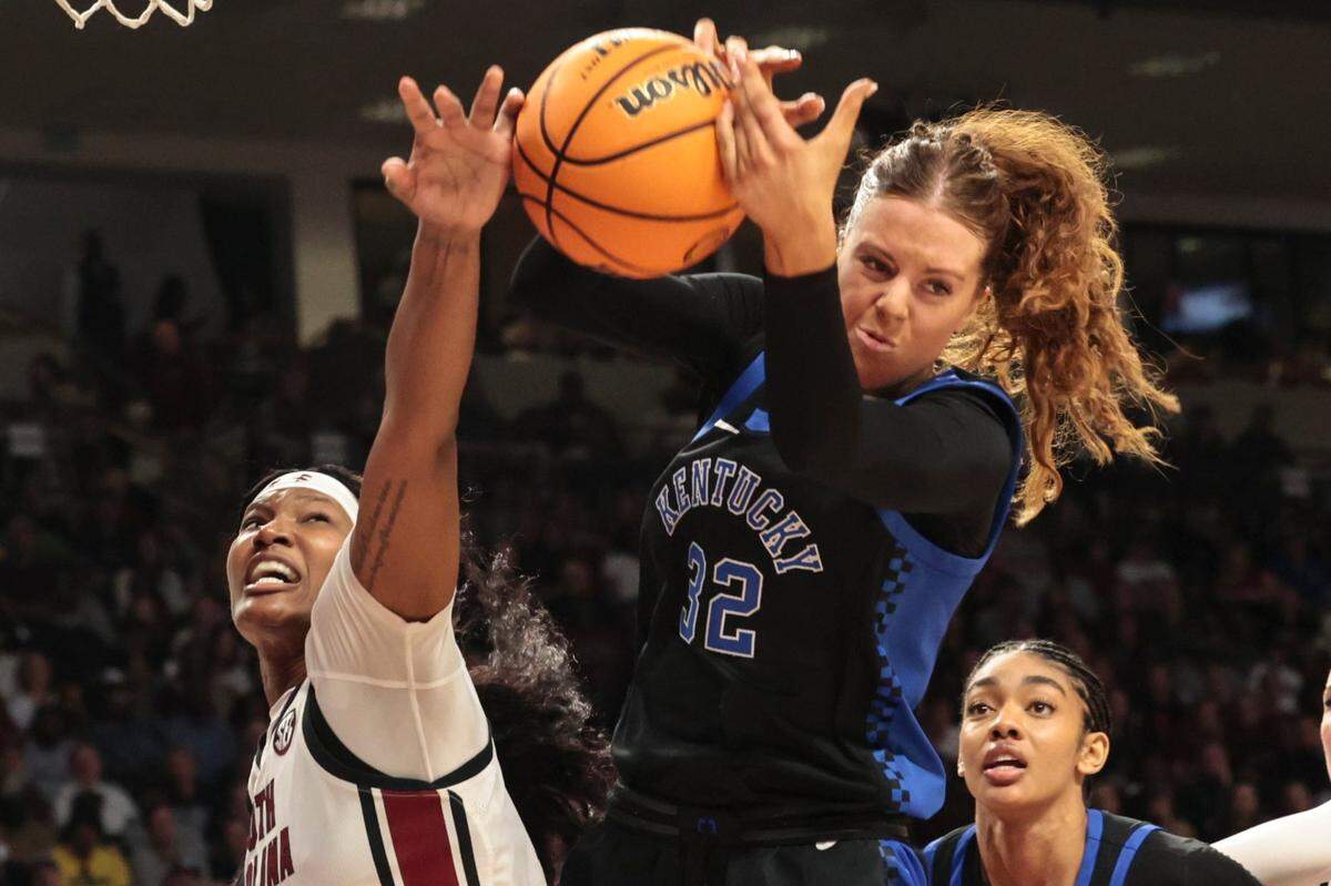South Carolina’s Sania Feagin (20) and Kentucky’s Amelia Hassett (32) go for a ball during the second half Sunday.