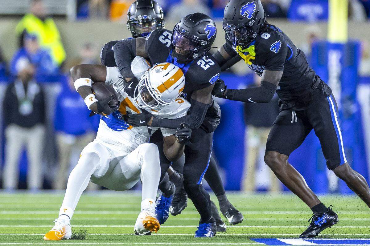 Kentucky defensive back Jordan Lovett (25) wraps up Tennessee wide receiver Radarious Jackson (5) during Saturday’s game at Kroger Field.