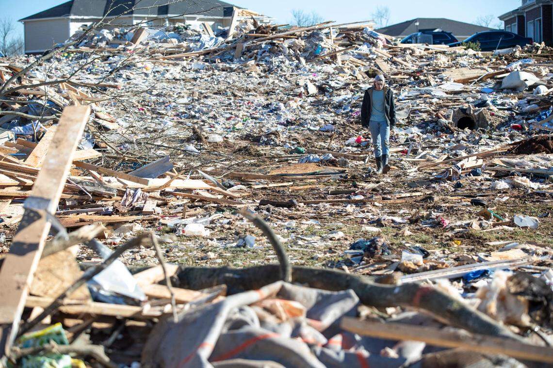 A man walks through the wrecked remains of houses in a neighborhood off Russellville Road after a tornado swept through Friday night in Bowling Green, Ky., Sunday, December 12, 2021.