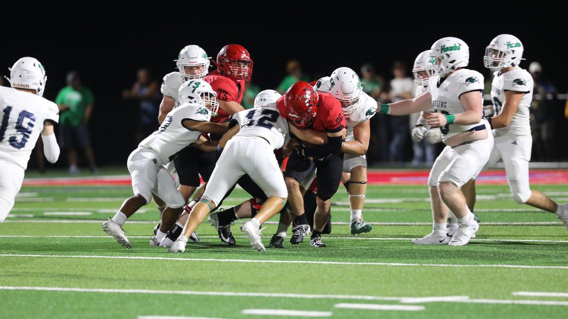 Great Crossing’s Sam Penn (12) and Jacob Johnson (13) stop a Scott County ball carrier during Friday night’s win.
