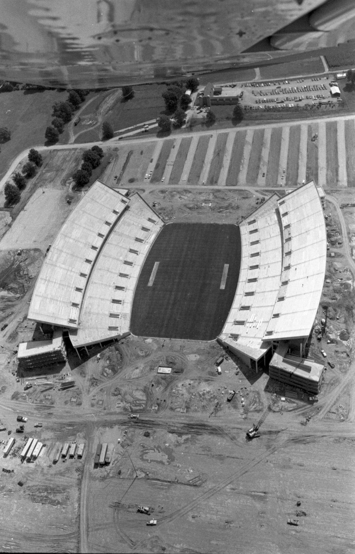 Aerial photo of what would be named Commonwealth Stadium, at the Univeristy of Kentucky, in mid August 1973. When construction was completed in September 1973, Commonwealth Stadium had a capacity of 57,800. It was built  at a cost of $12 million by the firm of Huber, Hunt, and Nichols. The stadium and parking areas rest on an 86-acre plot that was once part of the UK Experimental Station Farm Grounds. The stadium was officially opened on Sept. 15, 1973, as the Wildcats moved into their new home after spending 48 years at Stoll Field/McLean Stadium across from Memorial Coliseum. Kentucky defeated Virginia Tech in the stadium opener, 31-26, as quarterback Ernie Lewis ran for two touchdowns and threw for another TD to lead the Wildcats. Published in the Lexington Herald December 14, 1972. Herald-Leader Archive PhotoAerial of CWS, 8/19/73