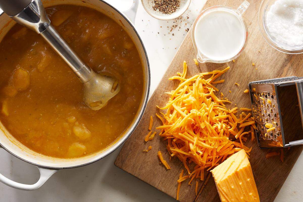 Grated cheddar is added to a potato-cheddar soup with quick-pickled jalapeños, in New York, Jan. 19, 2021. Silky-smooth and simple to make, it gets verve and heat from homemade pickled jalapeños. Food styled by Barrett Washburne. (Christopher Simpson/The New York Times)