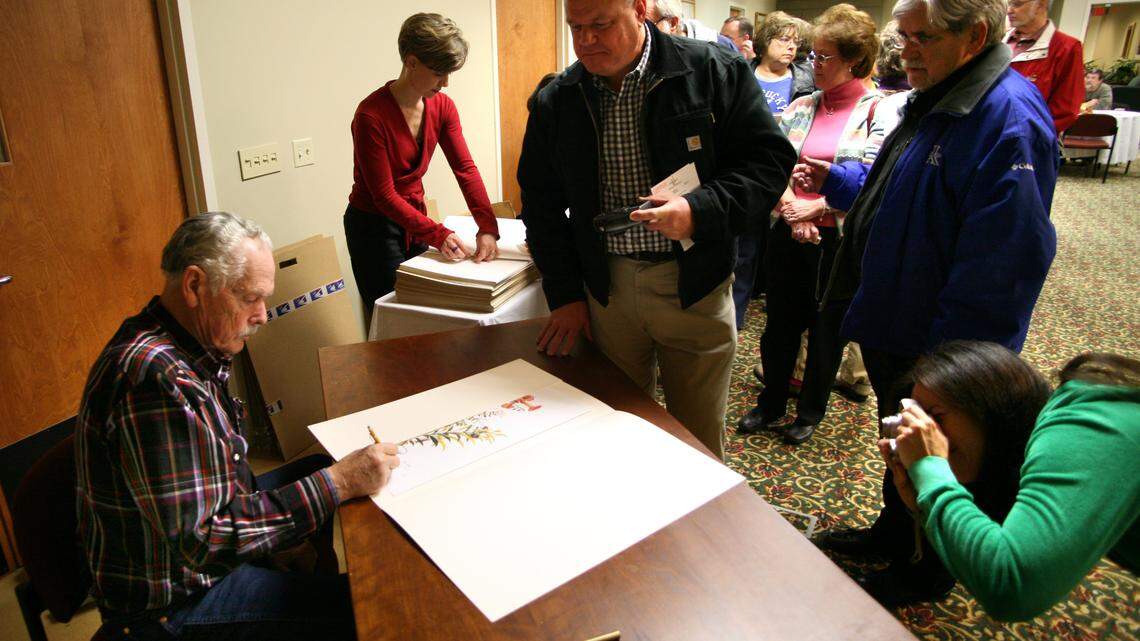 Ray Harm signed his print Hungry Hummers for Lexington coroner Gary Ginn, center, as Gina Lee Sandvik of Chicago, right, took a photo for her father, Leonard Smith, standing front right.