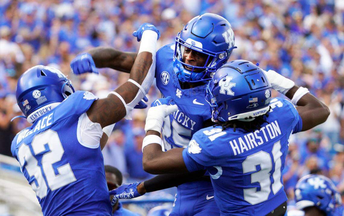 Kentucky defensive backs Jordan Lovett (25) and Maxwell Hairston (31) celebrate with linebacker Trevin Wallace (32), who had just made an interception against Florida.