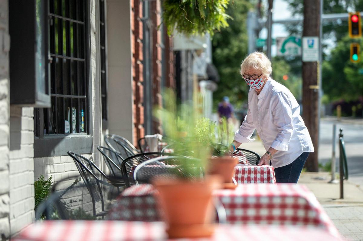 Flo Cowley, general manager at Columbia Steakhouse, ensures outside tables are properly spaced Friday, the first day restaurants in Kentucky could reopen to dine-in customers.