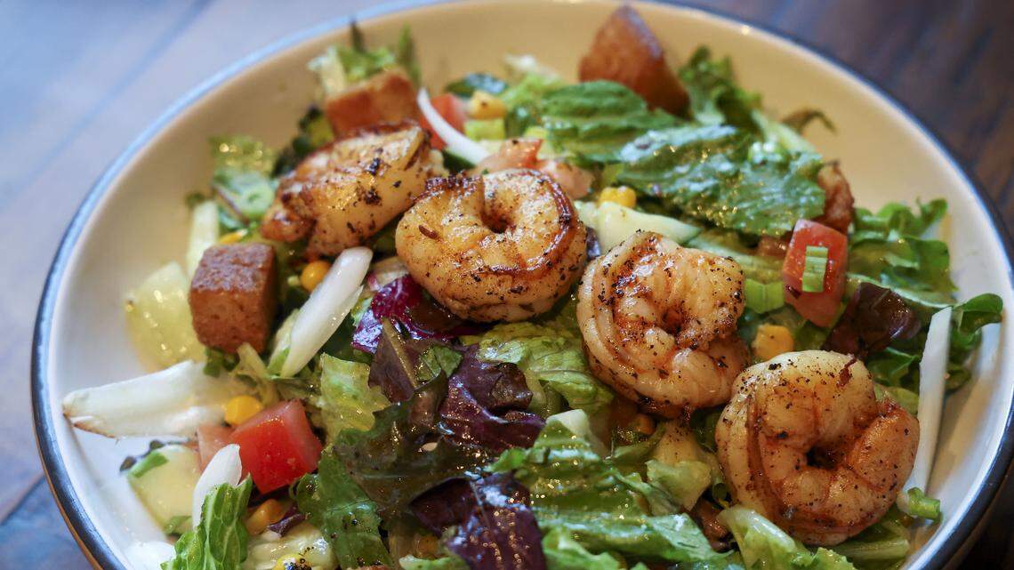 The blackened shrimp and cornbread salad ($15.95) from Southern Cookhouse & Bar, photographed Sunday, Sept.  7, in Lexington, Ky. The spring mix salad has tomato, roasted corn, red onion, cucumber, cilantro, green onions and cornbread crumbles tossed with a dijon vinaigrette.