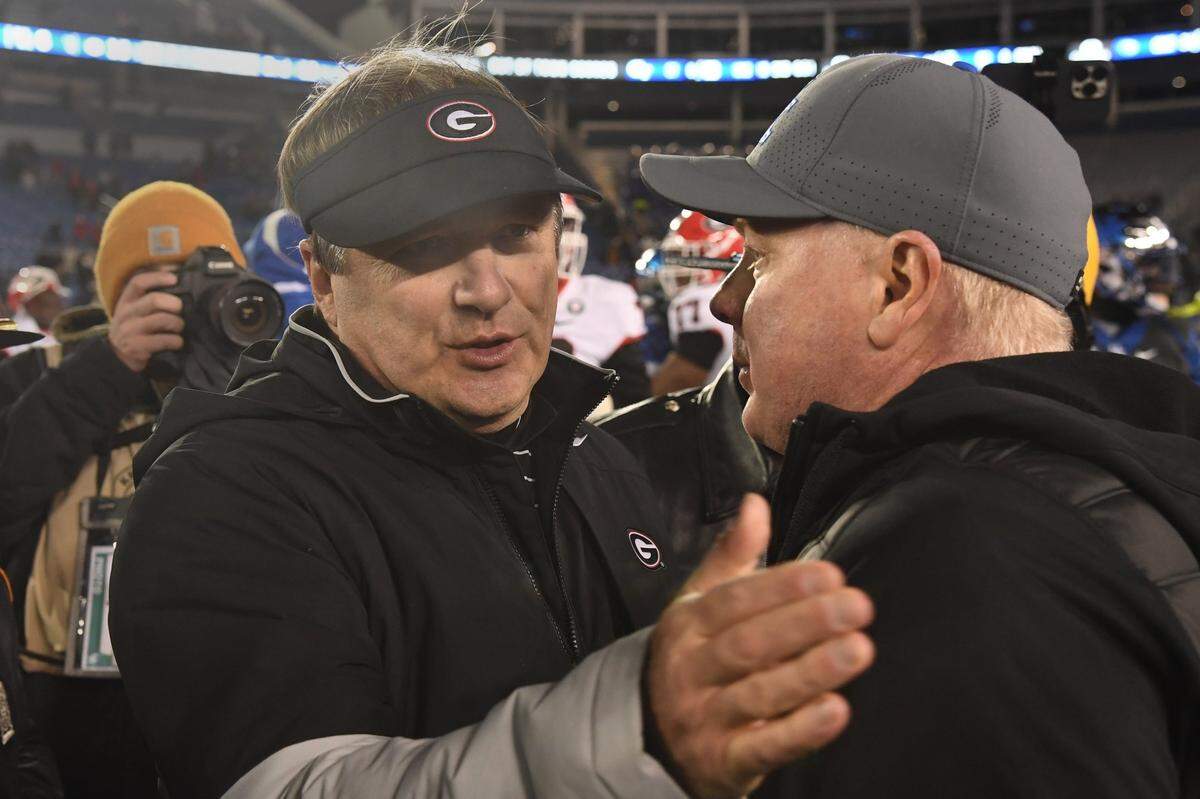 Georgia coach Kirby Smart, left, and Kentucky head man Mark Stoops, right, met after the Bulldogs beat the Wildcats 16-6 last season at Kroger Field. The Dawgs have won their past 13 meetings with the Cats.