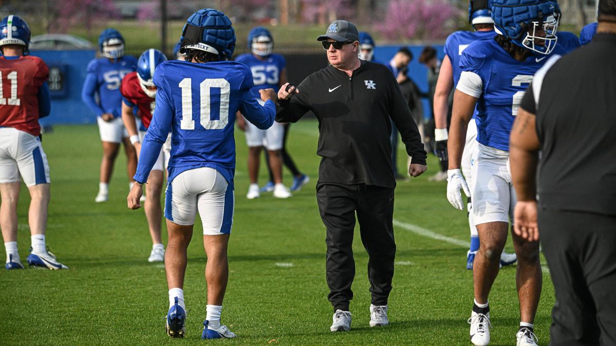Kentucky football head coach Mark Stoops fist bumps with running back Jamarion Wilcox before a practice on April 4.