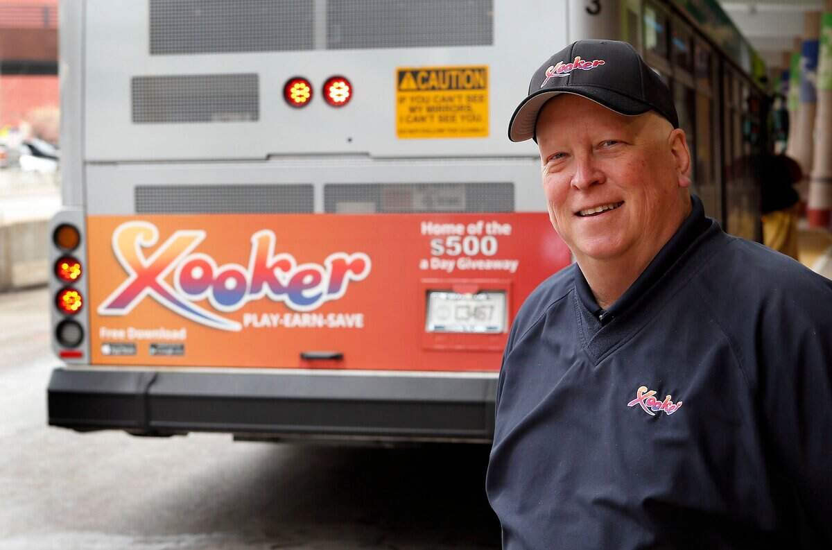 Conrad Carney, founder of Xooker, was photographed by one of his ads on the back of a Lextran bus in Lexington.