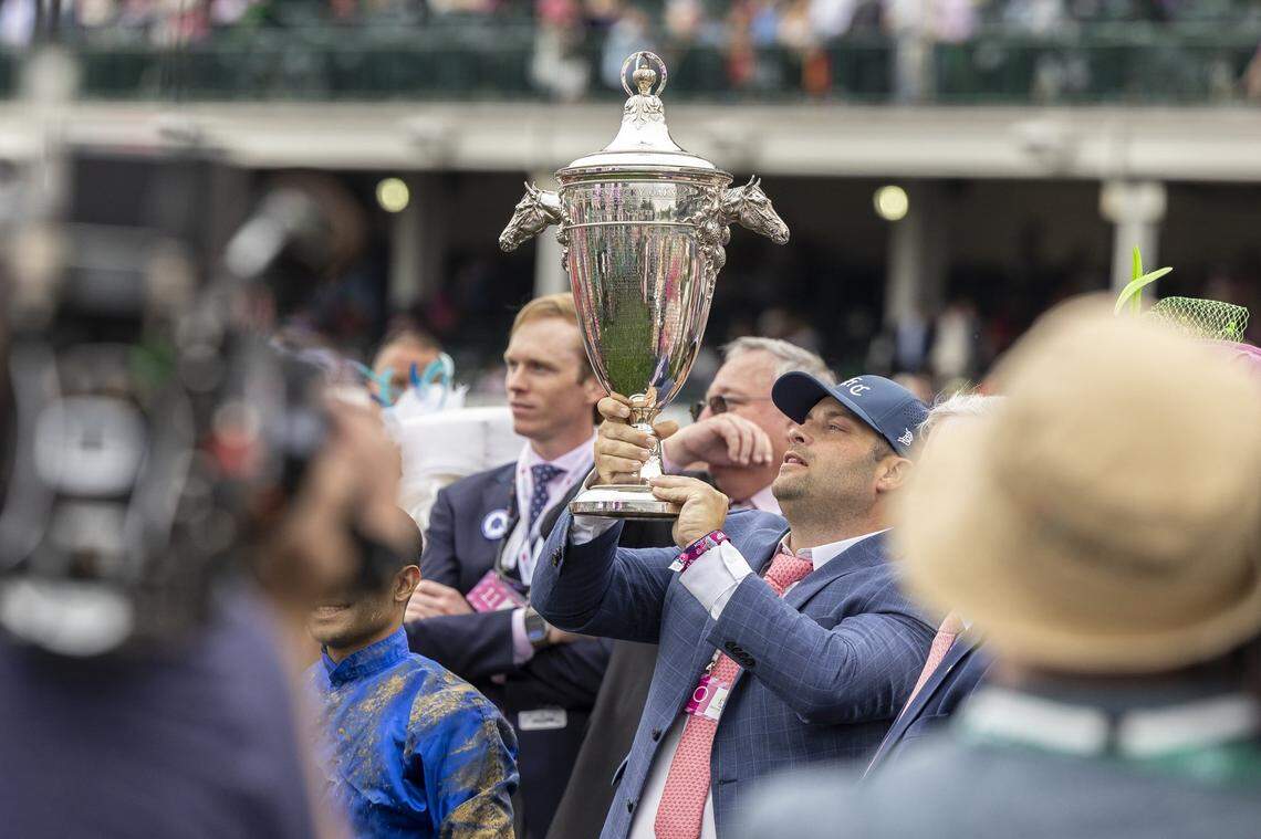 Trainer Brad Cox hoists the trophy after Good Cheer won the Kentucky Oaks on Friday.
