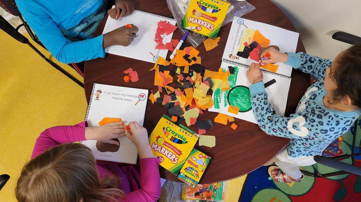 Children in a grief group work on an exercise about their feelings.
