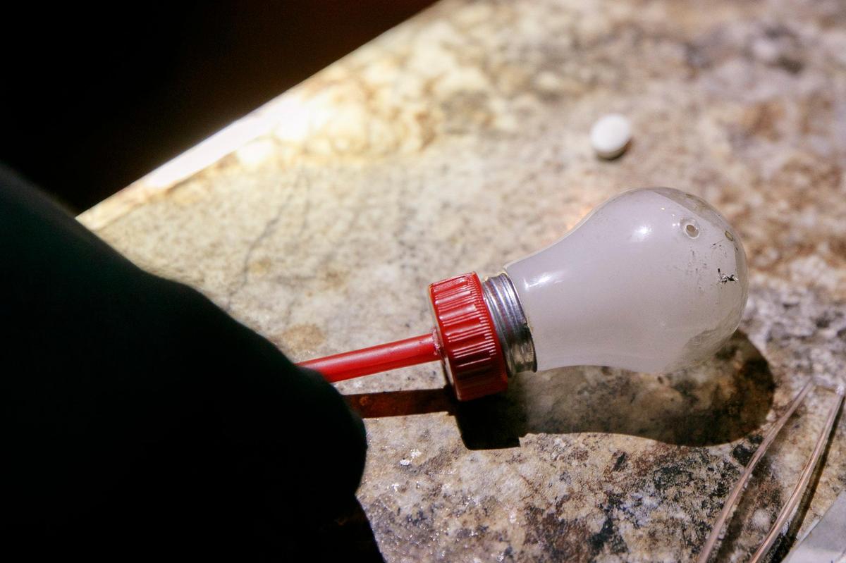 A makeshift methamphetamine pipe made from a light bulb and an unidentified pill sit on the counter of a home on Lancelot Court in Pikeville, Ky., Thursday, Aug. 8, 2019.