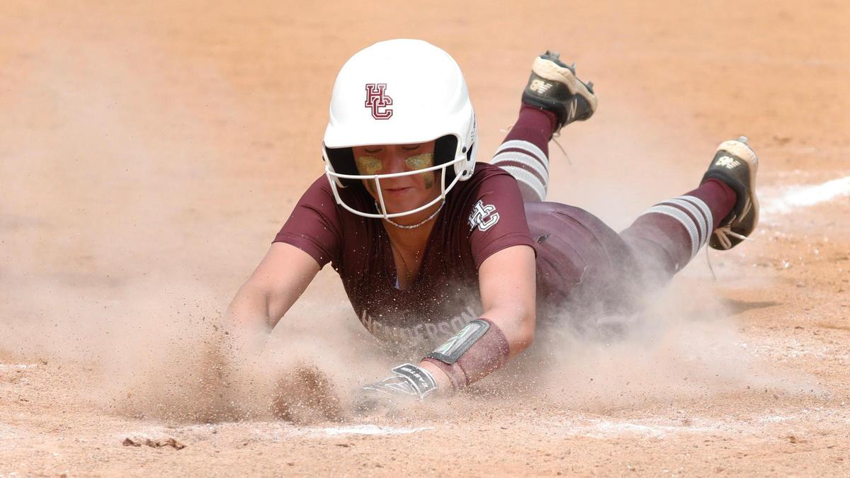 Henderson County’s Alyse Rollings dives into home plate to score one of the team’s four runs in the third inning.