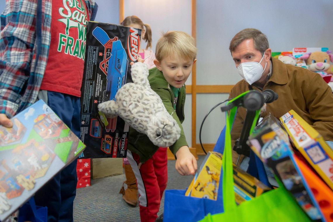 Hunter Wallace, 6, points out to Kentucky Gov. Andy Beshear the presents he selected at Kenlake State Resort Park in Hardin, Ky., on Tuesday, Dec. 21, 2021, as Christmas gifts donated for the Western Kentucky Toy Drive, organized by First Lady Britainy Beshear, were distributed to those affected by deadly tornadoes that ripped through Kentucky earlier in December.