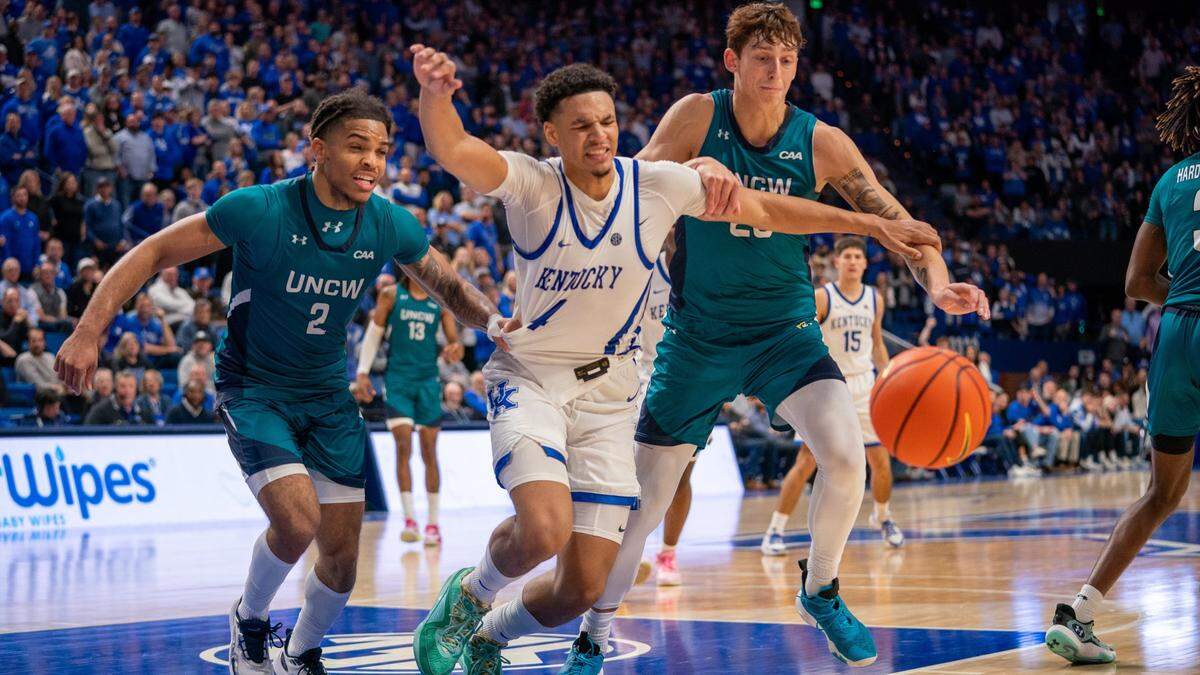 Kentucky’s Tre Mitchell (4) fights for a loose ball against North Carolina Wilmington’s Shykeim Phillips (2) and Eric Van Der Heijden during Saturday’s game in Rupp Arena. Mitchell finished with 11 points, six rebounds and three assists.