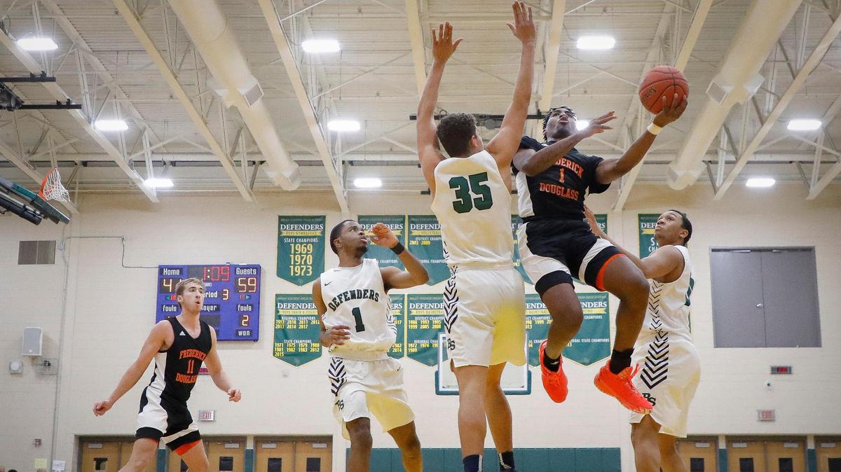 Frederick Douglass’ Dashawn Jackson (1) shoots past Bryan Station’s Pierre Petitfrere (1), Terik Mulder (35) and Trenton Grundy (10) during their game at Bryan Station High School on Friday, Jan. 29, 2021. Frederick Douglass beat Bryan Station 79-63.