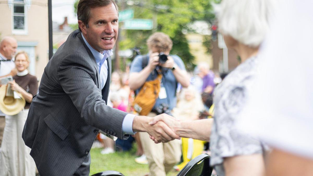 Governor Andy Beshear shakes hands with attendees during the ‘Towards Freedom’ monument unveiling on Thursday, June 19, 2025, at the corner of North Limestone and Fourth Street in Lexington, Ky.